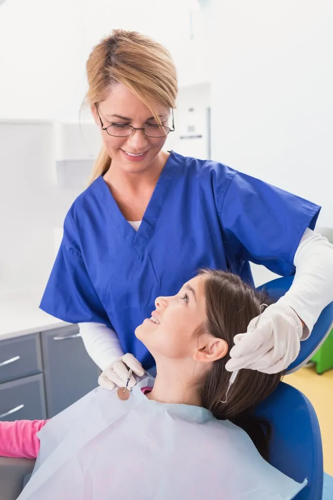 Smiling pediatric dentist with a happy young patient Smiling pediatric dentist with a happy young patient