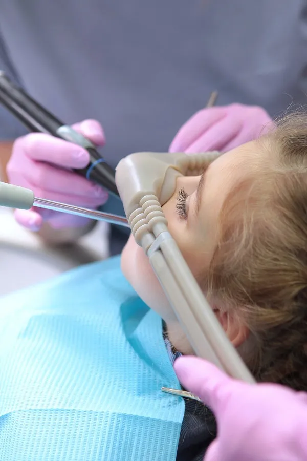 Dental treatment in a child with the use of nitrous oxide. Relaxation of the patient before surgical or dental procedures. Children's modern dentistry. The concept of healthcare. Dental treatment in a child with the use of nitrous oxide. Relaxation of the patient before surgical or dental procedures. Children's modern dentistry. The concept of healthcare.Vertical photo.