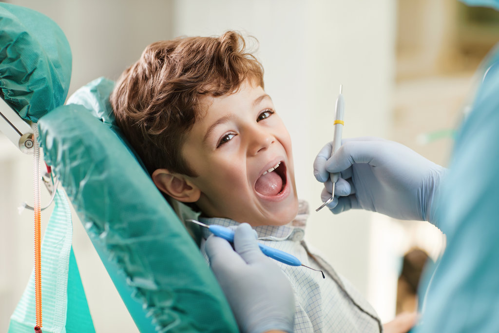 Child smiling while sitting in the dentist's chair. Beautiful child smiling while sitting in the dentist's chair. Close-up.