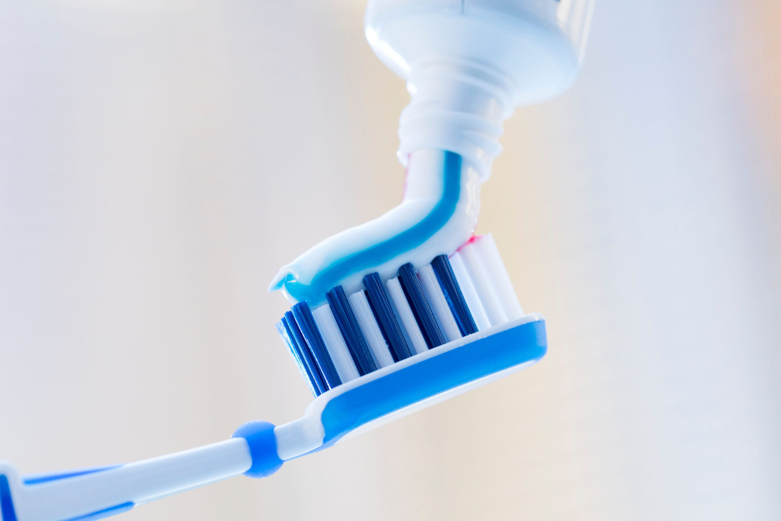 Closeup of a toothbrush and toothpaste on blurred background Closeup of a toothbrush and toothpaste on blurred background