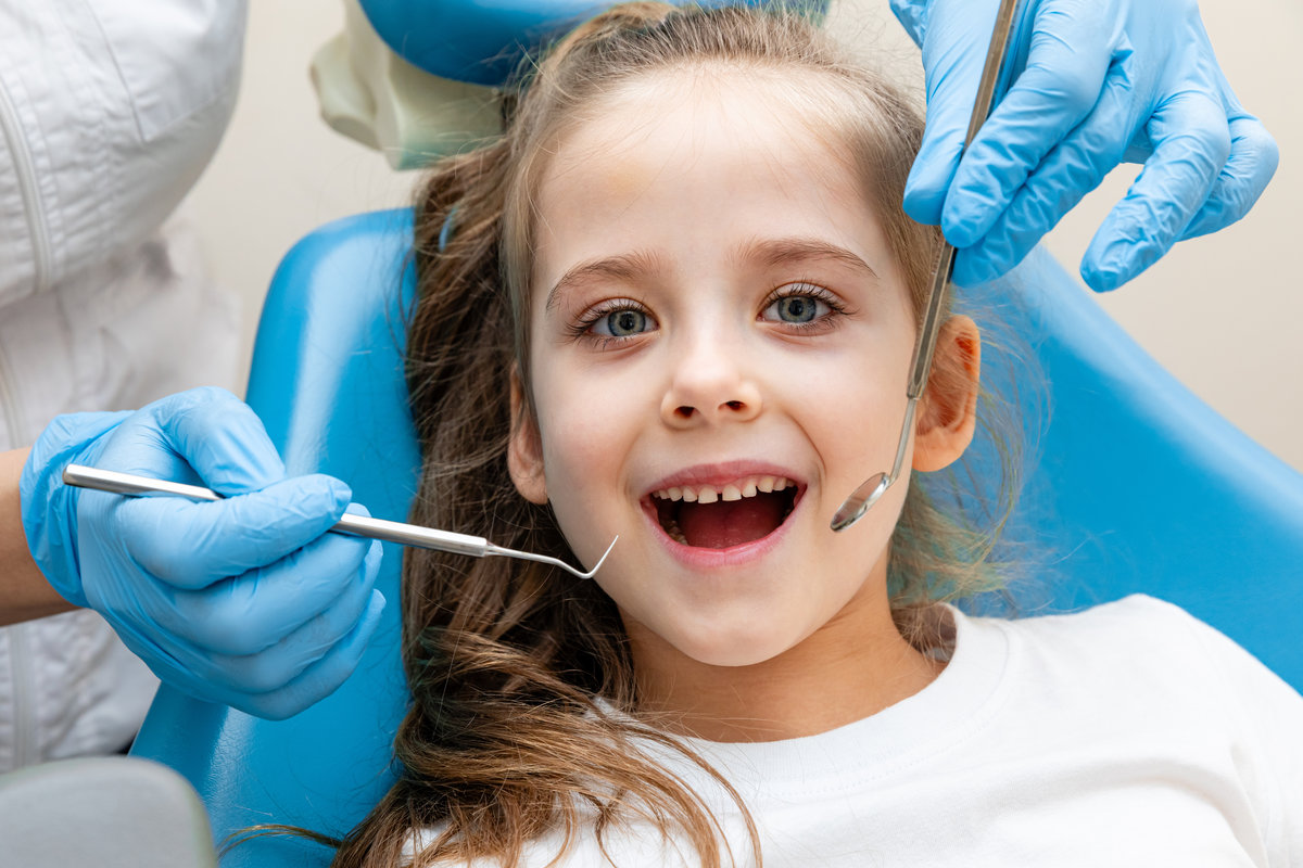 dentist, doctor examines the oral cavity of a little girl, uses a mouth mirror, baby teeth close-up, the concept of pediatric dentistry, dental treatment. dentist, doctor examines the oral cavity of a little girl, uses a mouth mirror, baby teeth close-up, the concept of pediatric dentistry, dental treatment.
