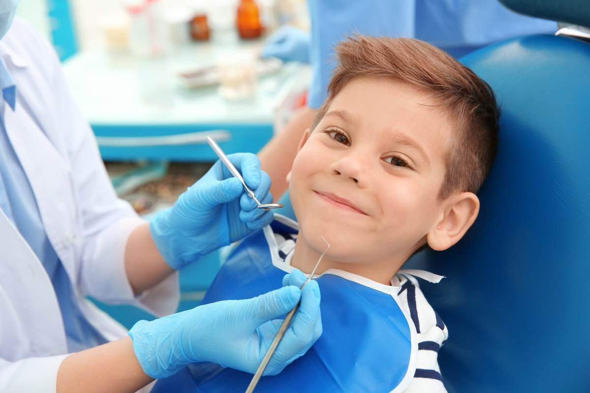 Dentist examining little boy's teeth in clinic Dentist examining little boy's teeth in clinic