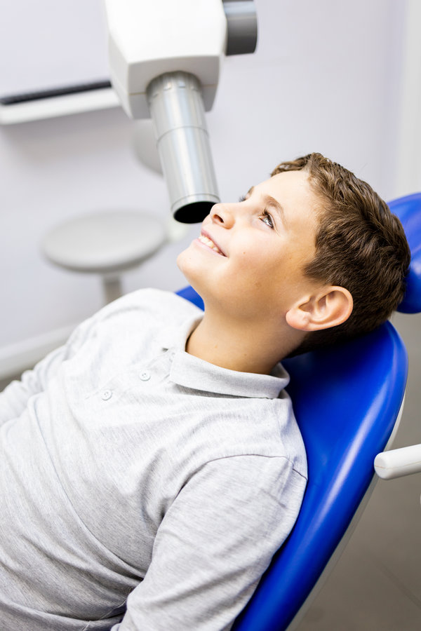 A Caucasian boy between 9 and 10 years old visits a dentist clinic to have an intraoral x-ray to identify cases of cavities,Intraoral x-ray concept. A Caucasian boy between 9 and 10 years old visits a dentist clinic to have an intraoral x-ray to identify cases of cavities,Intraoral x-ray concept.