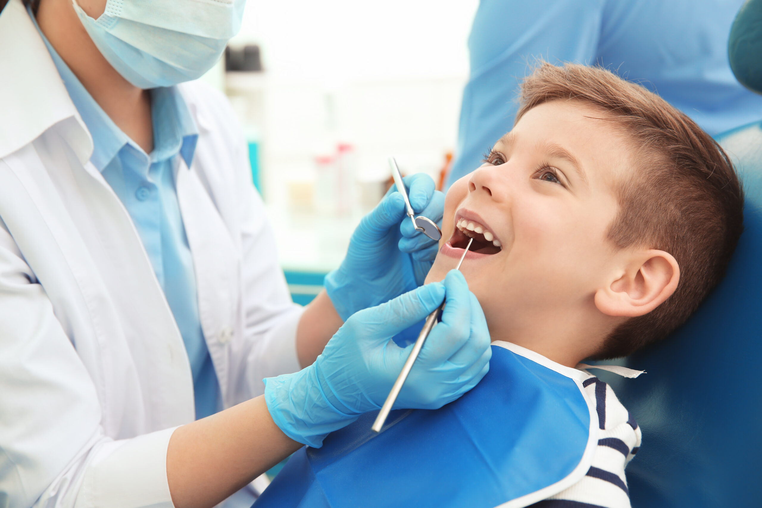 Dentist examining little boy's teeth in clinic Dentist examining little boy's teeth in clinic