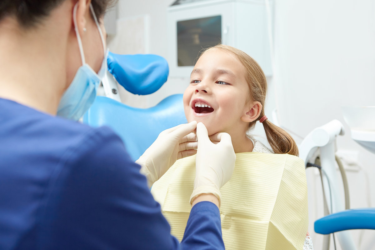 A little child in the examination at the dentist. Observation of teeth of young patient. A little child in the examination at the dentist. Observation of teeth of young patient. A sweet five year old girl opens her mouth in the doctor's office.