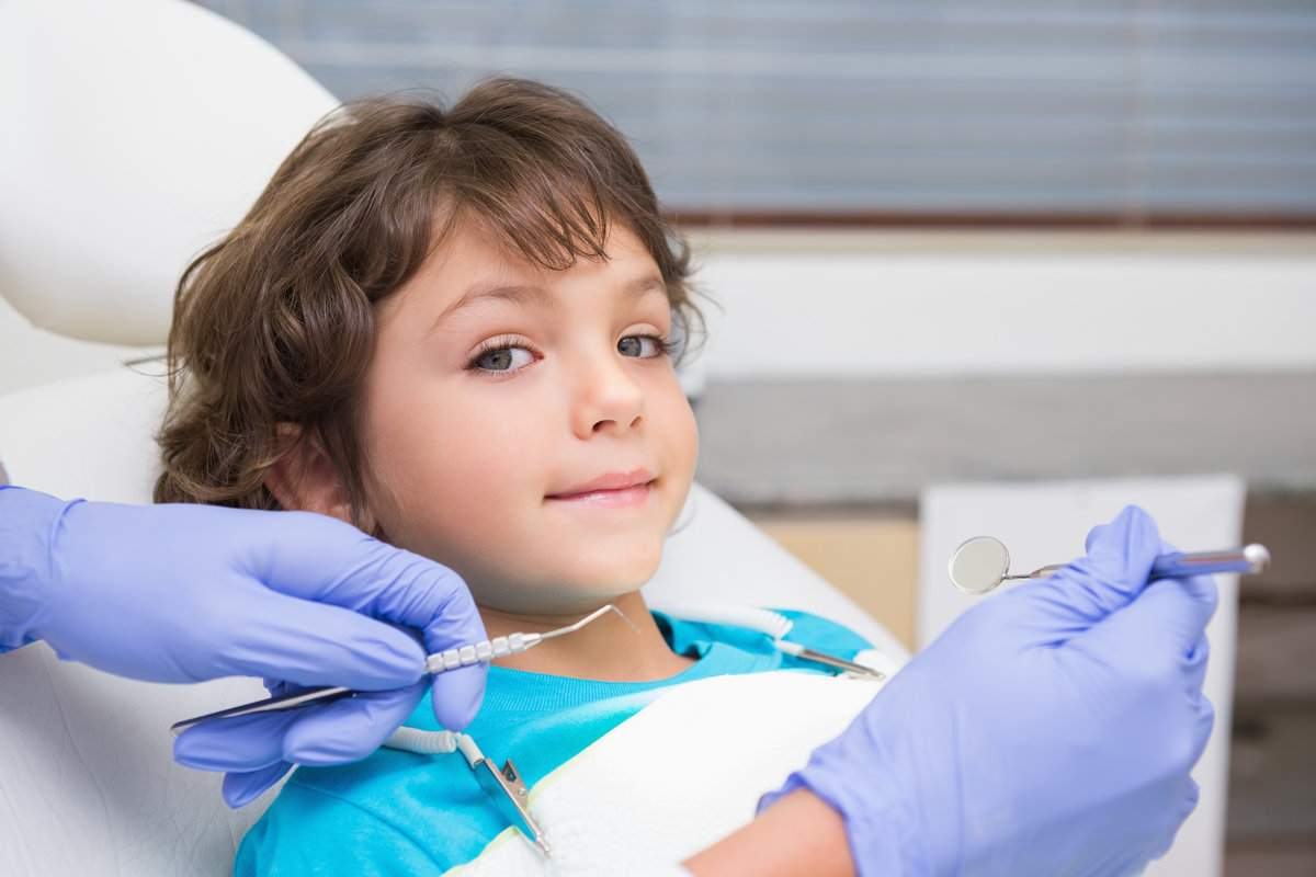 Pediatric dentist examining a little boys teeth Pediatric dentist examining a little boys teeth